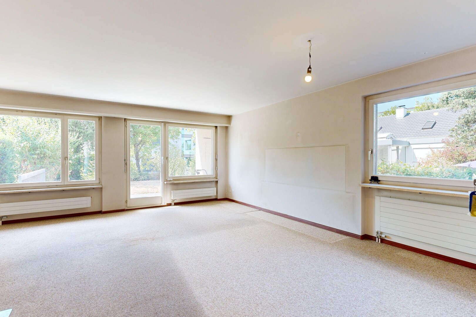 leerer raum mit kühler, pendelleuchte, gipskartonwand, drywall, und natürliches licht