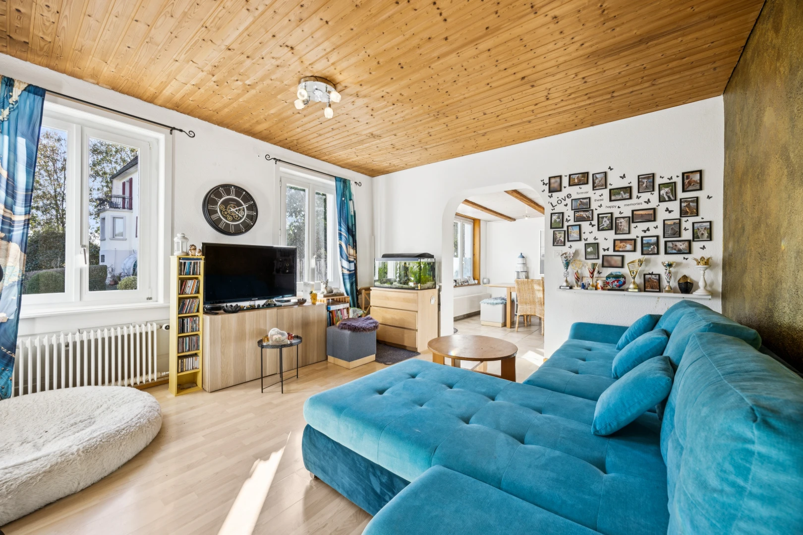 living room featuring radiator, wood ceiling, arched walkways, and light wood-style flooring
