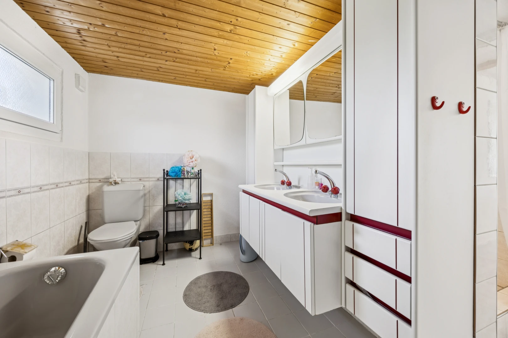 full bathroom with double vanity, wooden ceiling, tile walls, a bath, and light tile patterned flooring