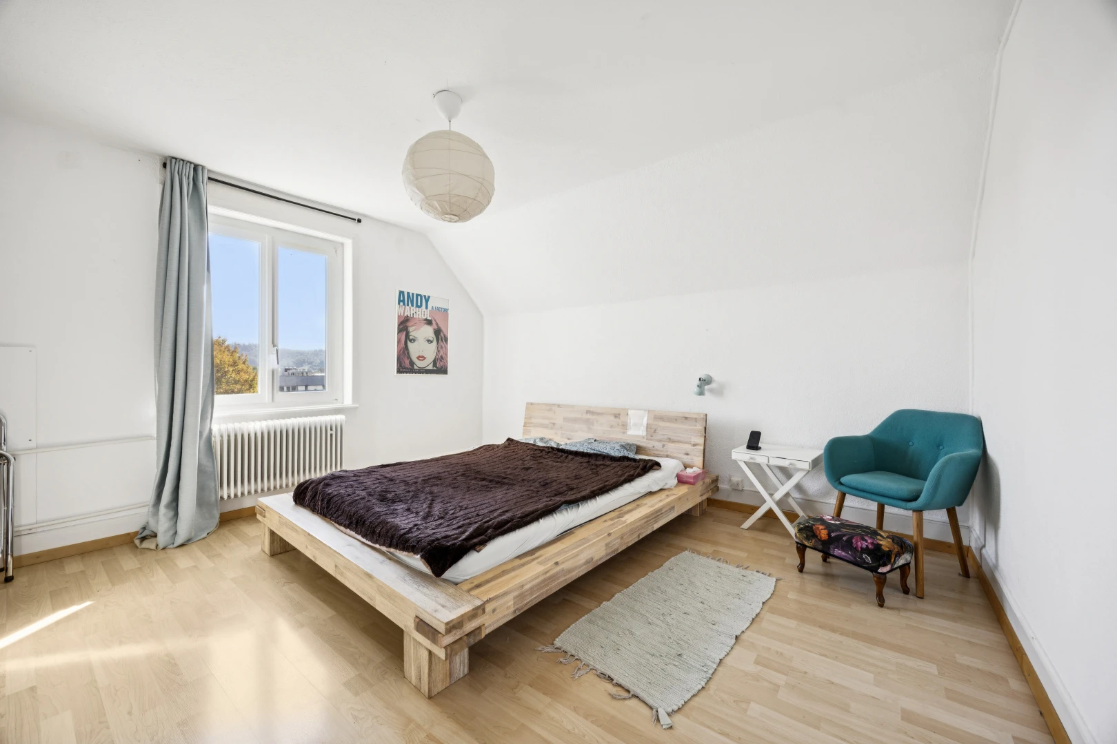 room featuring radiator heating unit, lofted ceiling, and light wood-style flooring