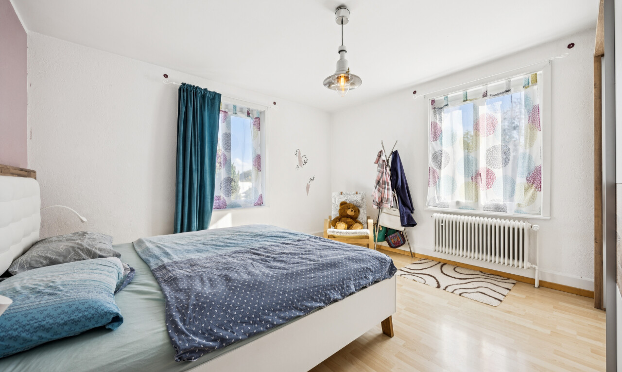 room featuring light wood-style floors, radiator, and decorative light fixtures