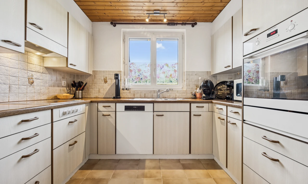 cuisine avec light floor, lave-vaisselle, dosseret, backsplash, et plafond en bois