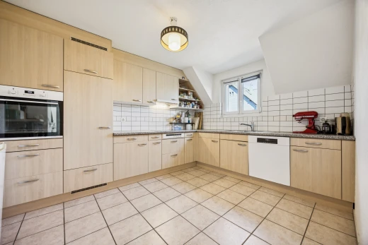 kitchen featuring light wood finish cabinetry, oven, dishwasher, backsplash, and open shelves