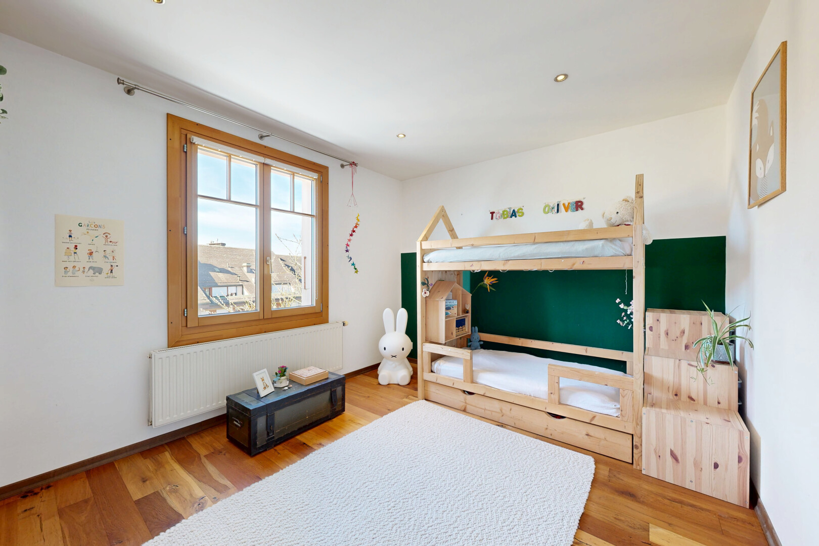 salon avec cloison sèche, drywall, sol en finition bois, wood finish floor, et radiateur