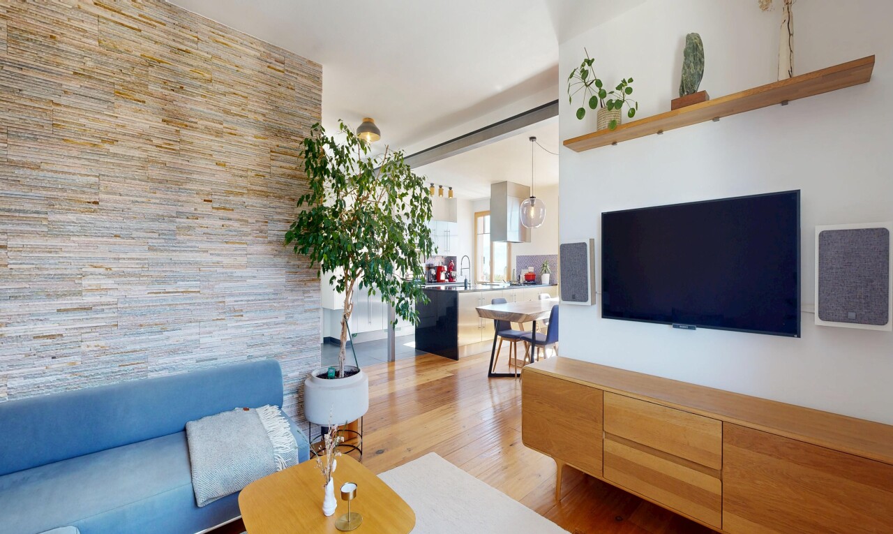 salon avec télévision, inside property, wood finish floor, sol en finition bois, et drywall