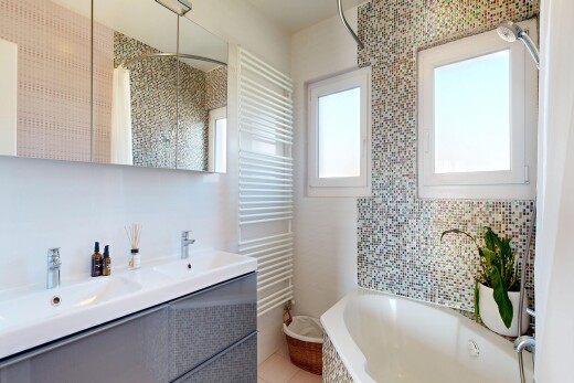 full bathroom featuring radiator heating unit, double vanity, a garden tub, tiled shower, and a towel warming rack
