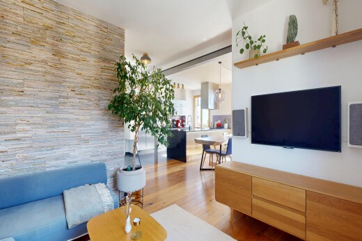 salon avec télévision, inside property, wood finish floor, sol en finition bois, et drywall