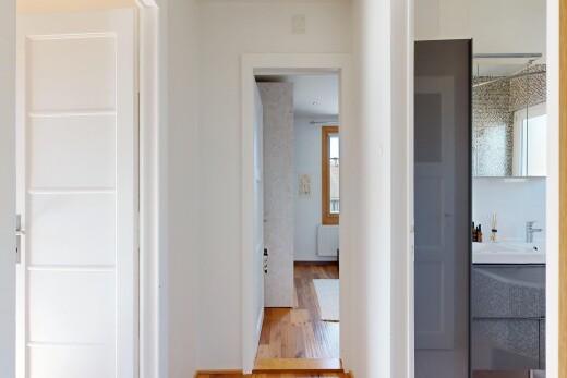 couloir avec cloison sèche, drywall, sol en finition bois, wood finish floor, et lumière naturelle