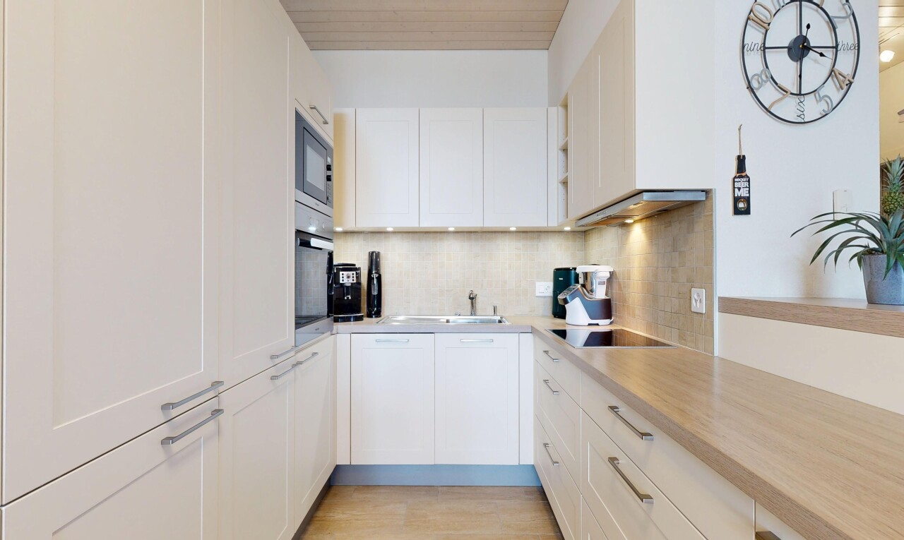 kitchen with light countertops, backsplash, white cabinets, and black appliances