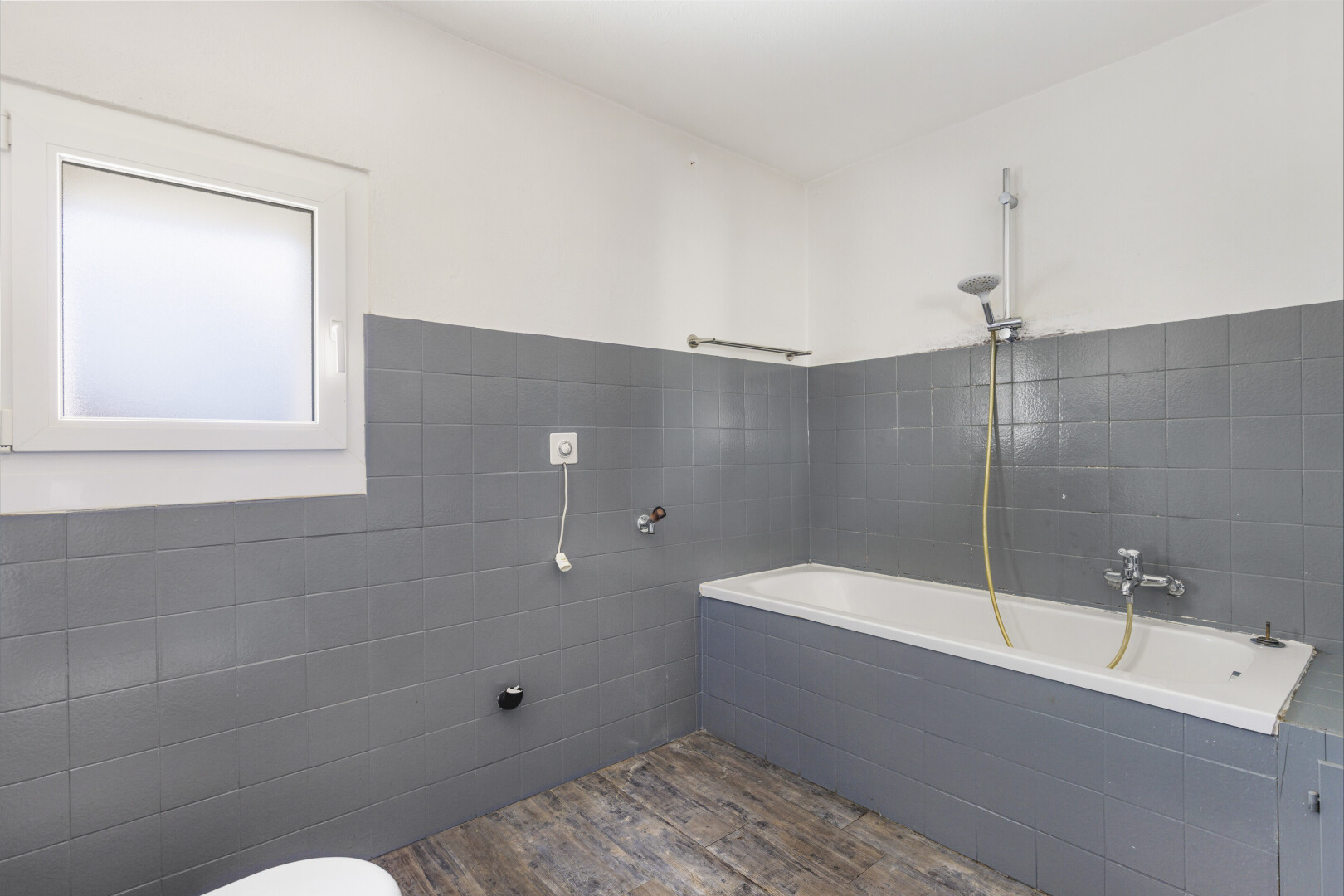 salle de bains avec mur en carrelage, tile wall, inside property, salle de bain complète, et sol en finition bois