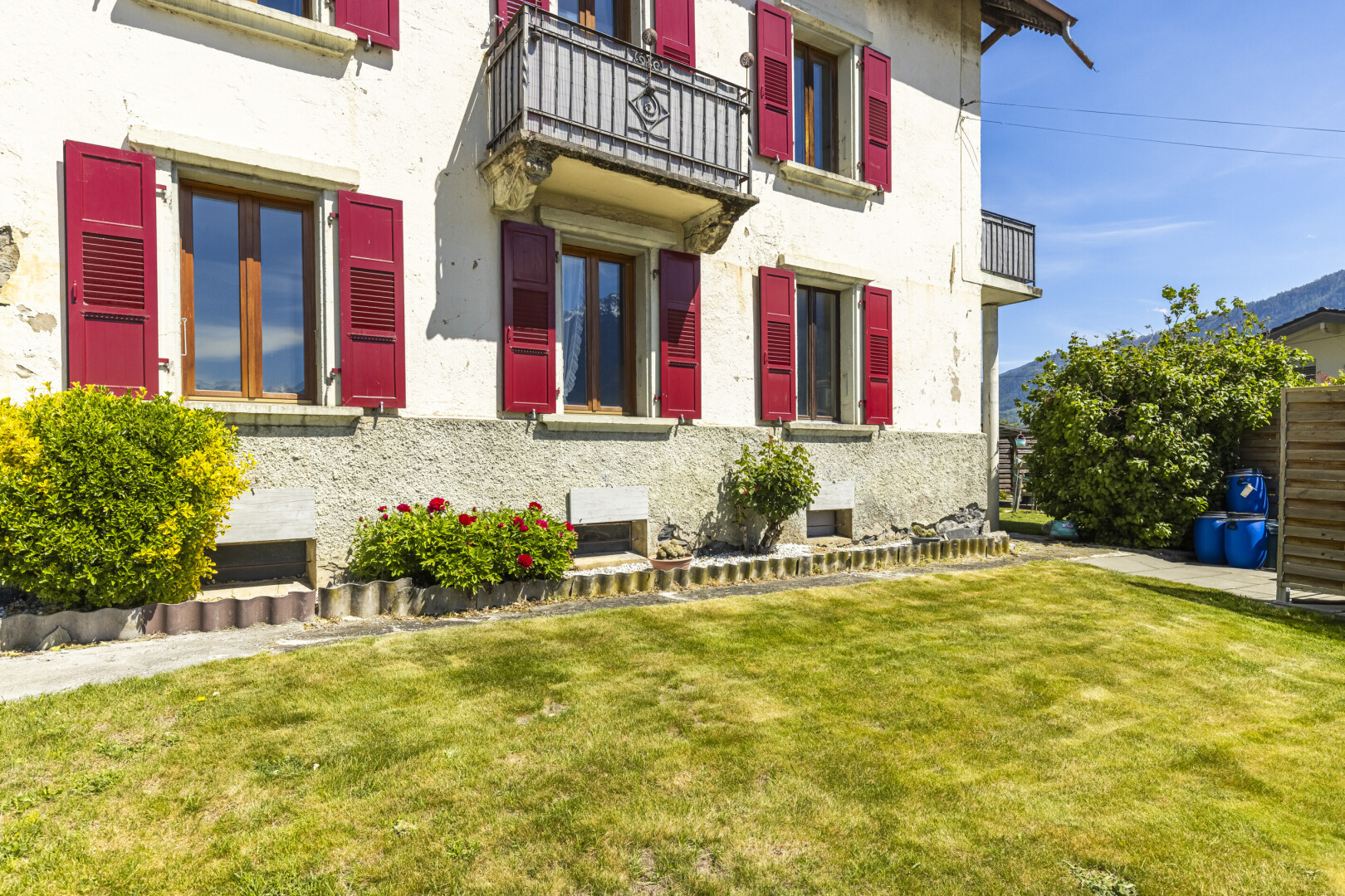 façade avec pelouse, balcon, property visible, bardage en stuc, et day time