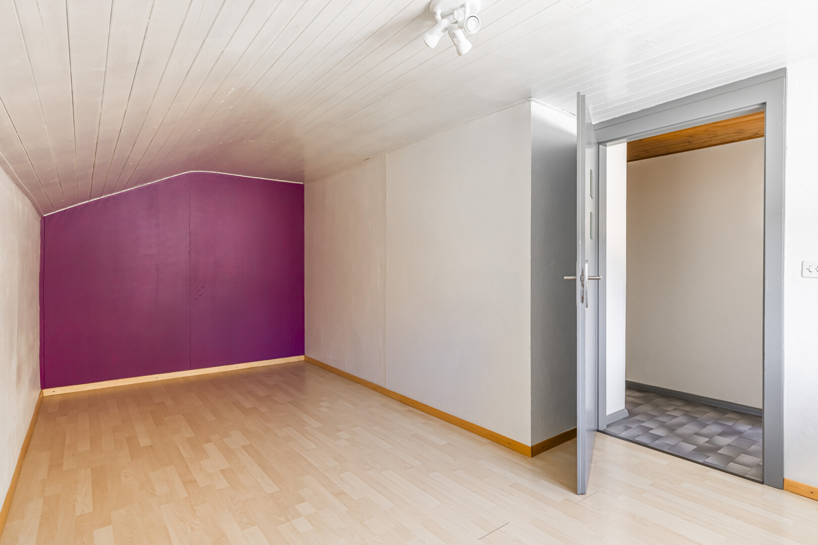 pièce vide avec plafond voûté, vaulted ceiling, inside property, sol en finition bois, et wood finish floor