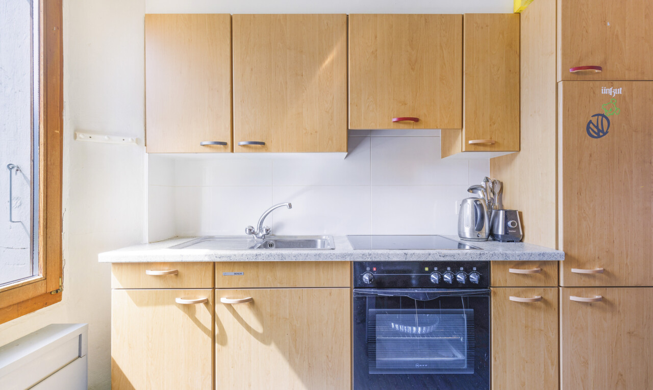 küche mit ofen, light countertops, inside property, light brown cabinets, und hellbraune schränke