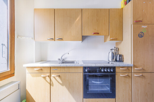 cuisine avec four, light countertops, inside property, light brown cabinets, et armoires marron clair