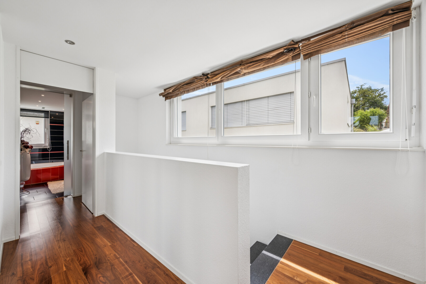 corridor with dark wood finished floors and healthy amount of natural light
