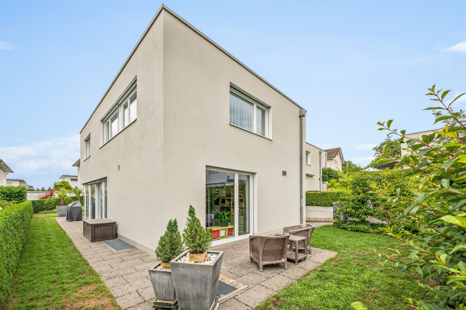 view of home featuring a patio area, a lawn, and stucco siding