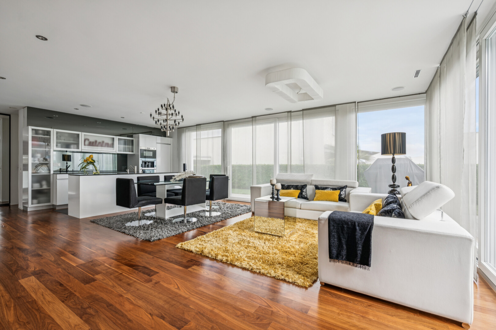 living room featuring dark wood-style flooring and suspended lighting
