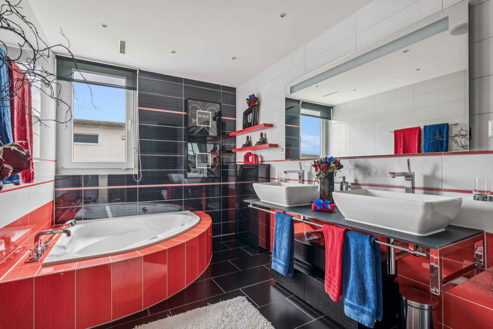 full bathroom featuring tile walls, a bath, double vanity, and dark tile patterned floors