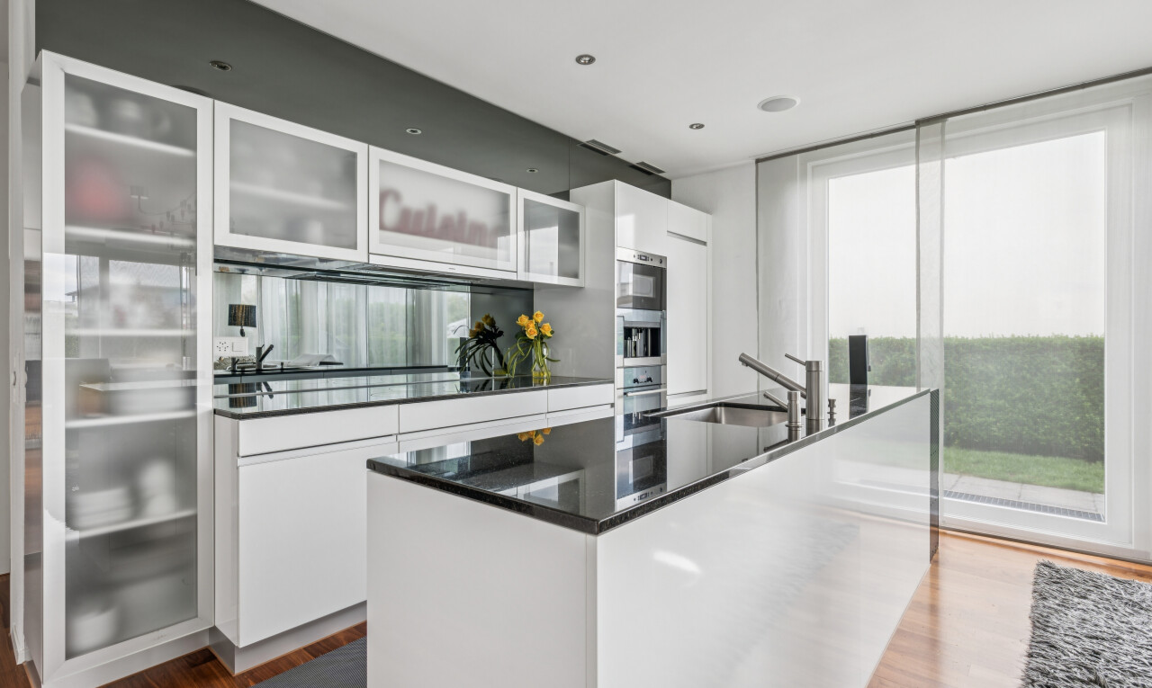 kitchen featuring glass fronted cabinets, white cabinetry, dark wood-type flooring, a kitchen island with sink, and stainless steel appliances