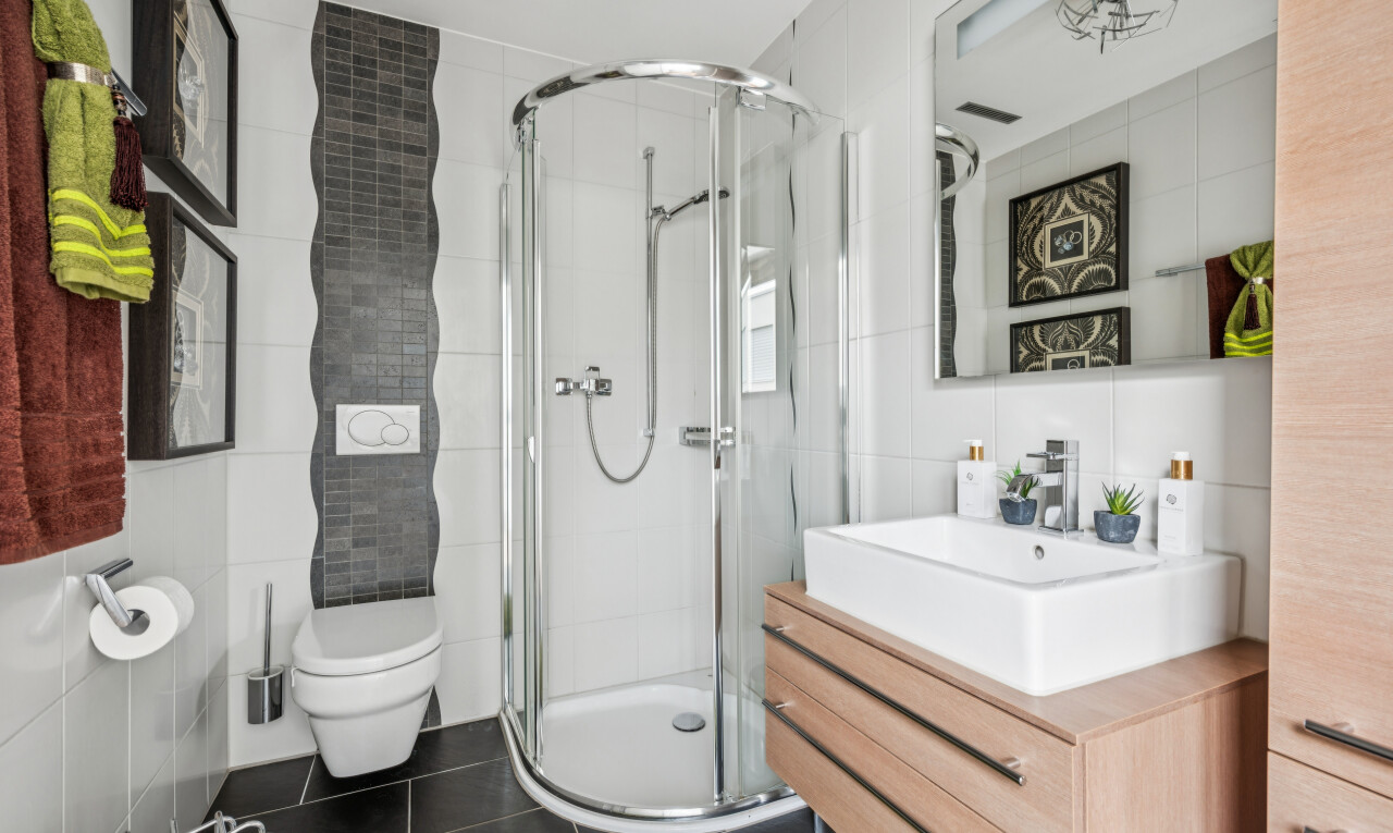 bathroom with tile walls, a stall shower, vanity, and dark tile patterned flooring