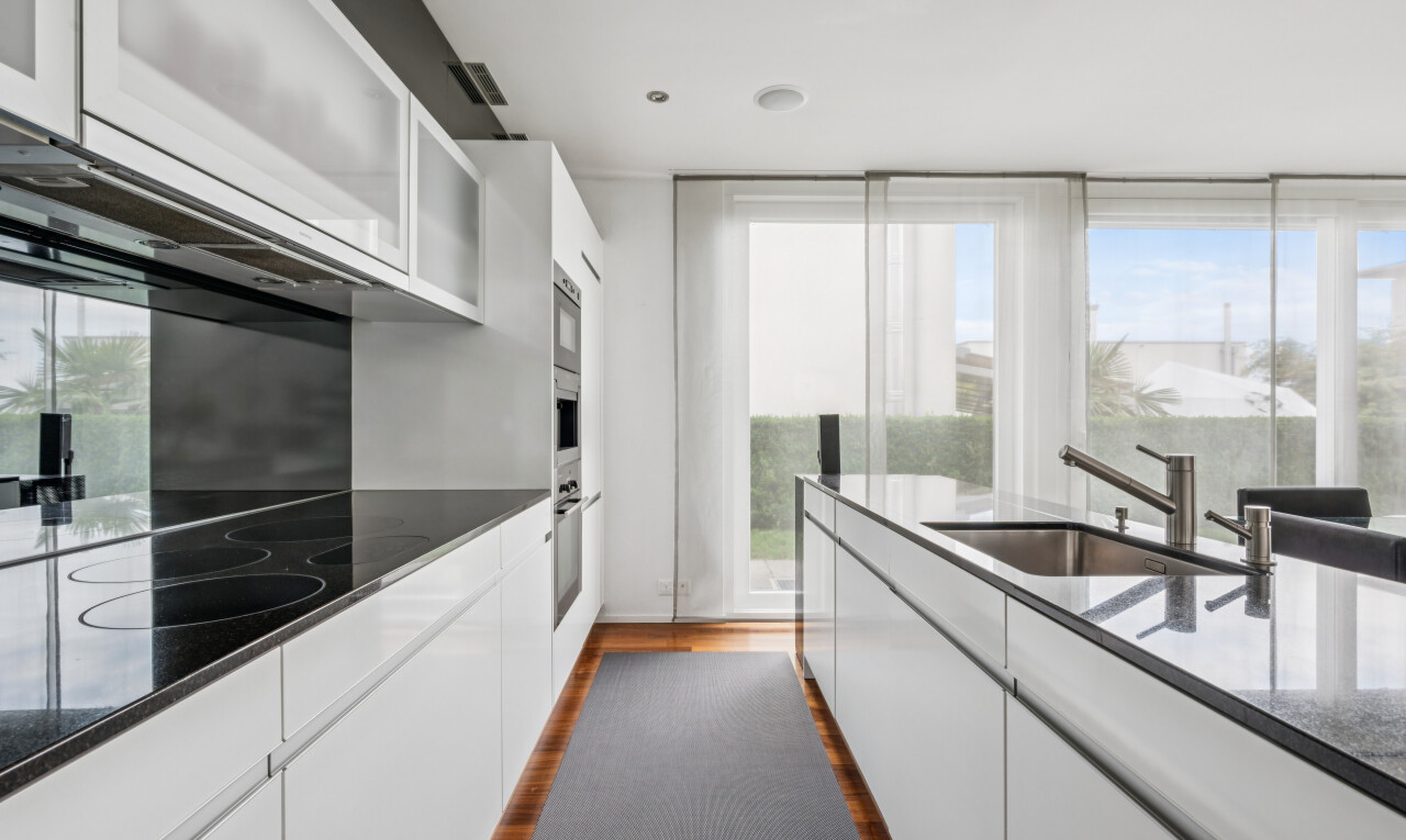 kitchen with white cabinets, dark wood-style floors, dark stone countertops, stainless steel oven, and glass insert cabinets