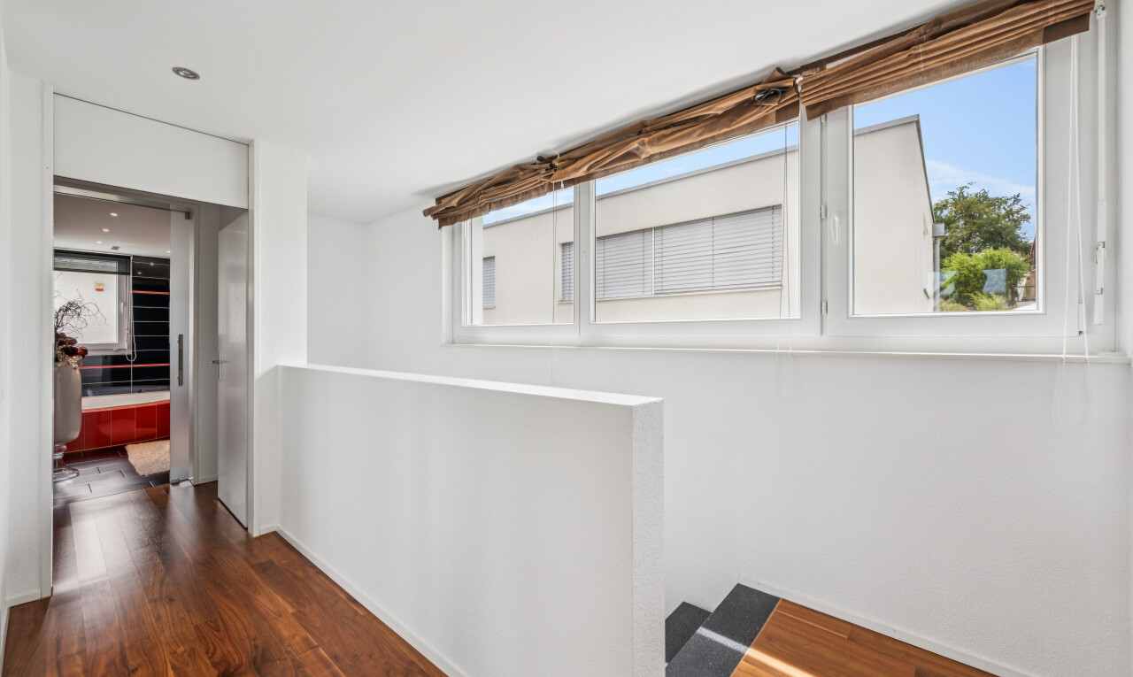 corridor with dark wood finished floors and healthy amount of natural light