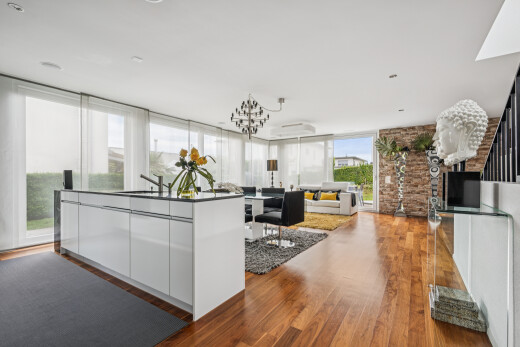 kitchen with an island with sink, dark wood finished floors, open floor plan, modern cabinets, and white cabinets