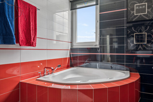 bathroom featuring tile walls, tiled tub, and a shower