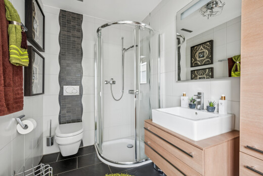 bathroom with tile walls, a stall shower, vanity, and dark tile patterned flooring
