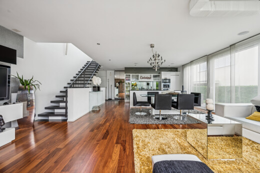 living / dining area with dark wood-type flooring and suspended lighting