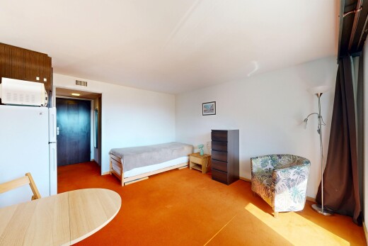 room with freestanding refrigerator and light colored carpet