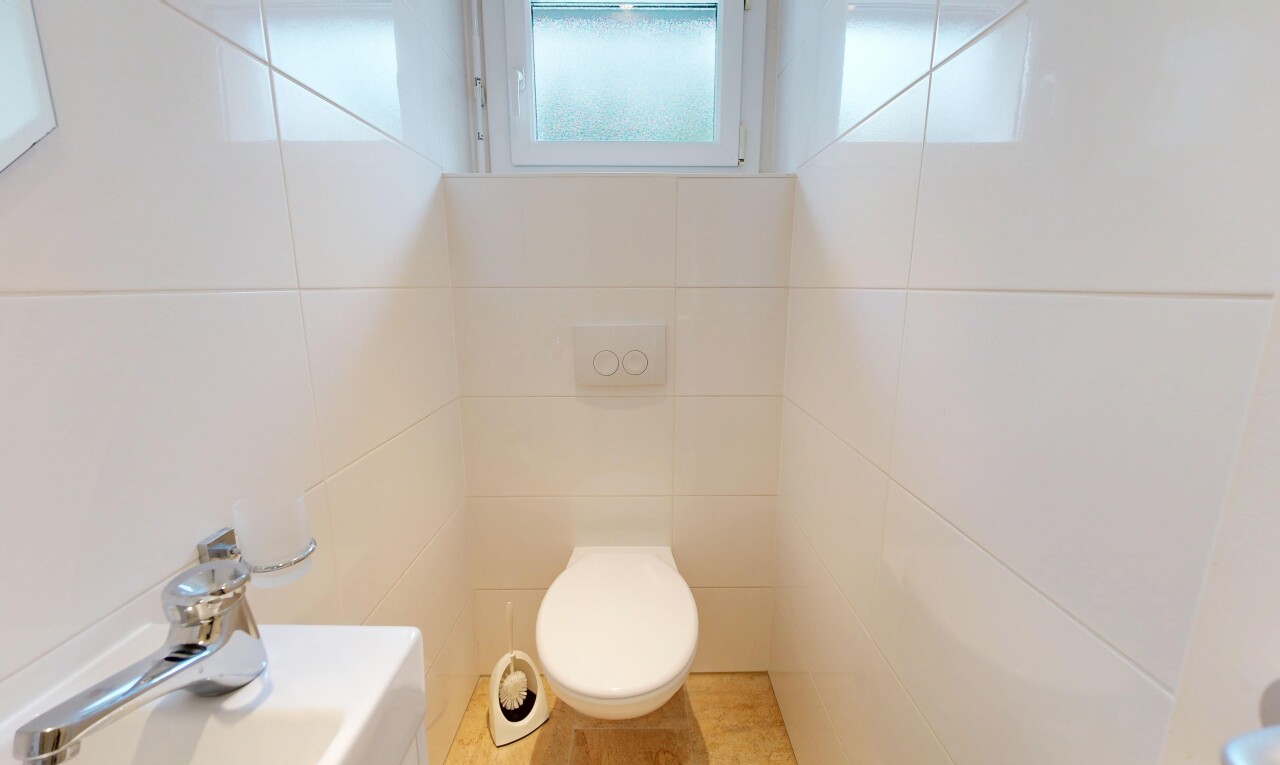 salle de bains avec inside property, tile wall, mur en carrelage, toilette, et natural light