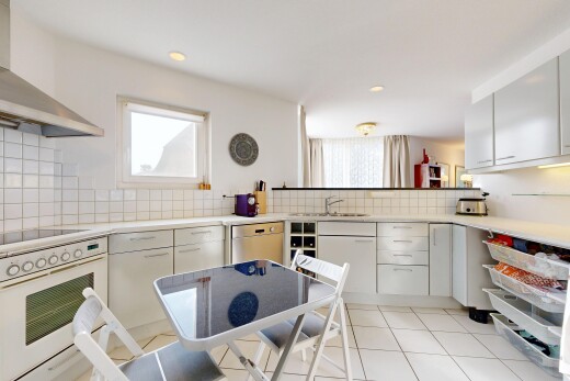 cuisine avec hotte, four, light countertops, plans de travail, et light floor