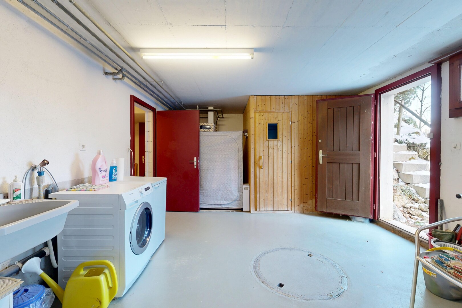 buanderie avec sol en béton, concrete floor, inside property, mur en bois, et wood wall