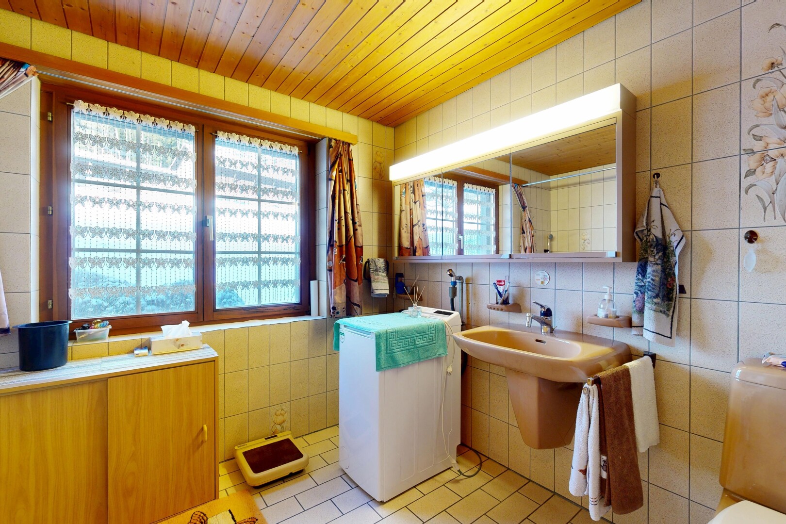 salle de bains avec mur en carrelage, tile wall, miroir, lumière naturelle, et natural light