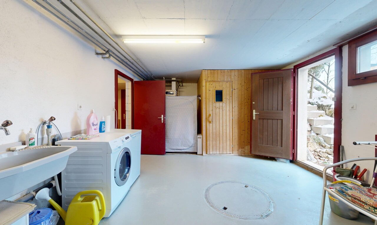 buanderie avec sol en béton, concrete floor, inside property, mur en bois, et wood wall