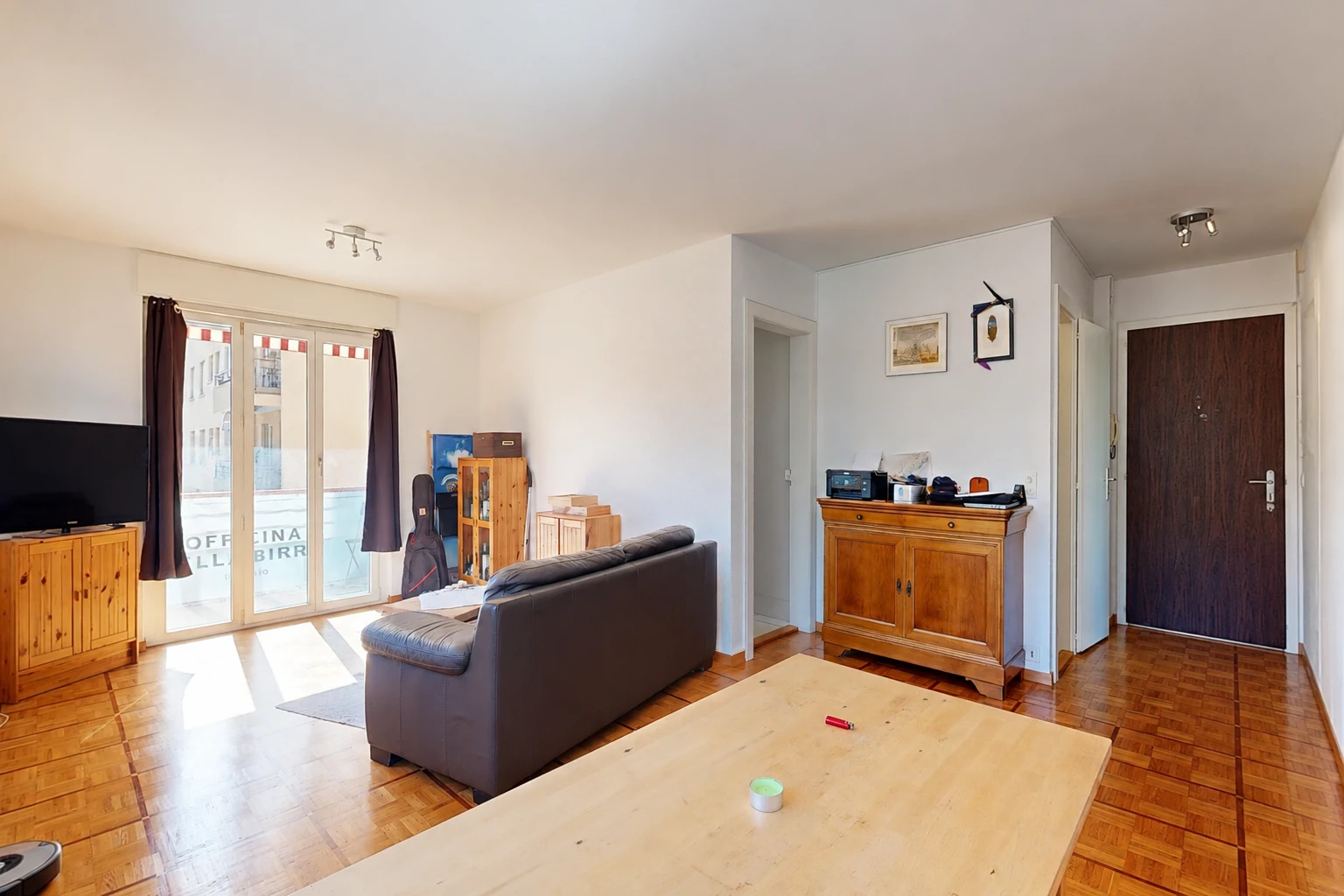 salon avec télévision, cloison sèche, drywall, accès à l'extérieur, et sol en finition bois