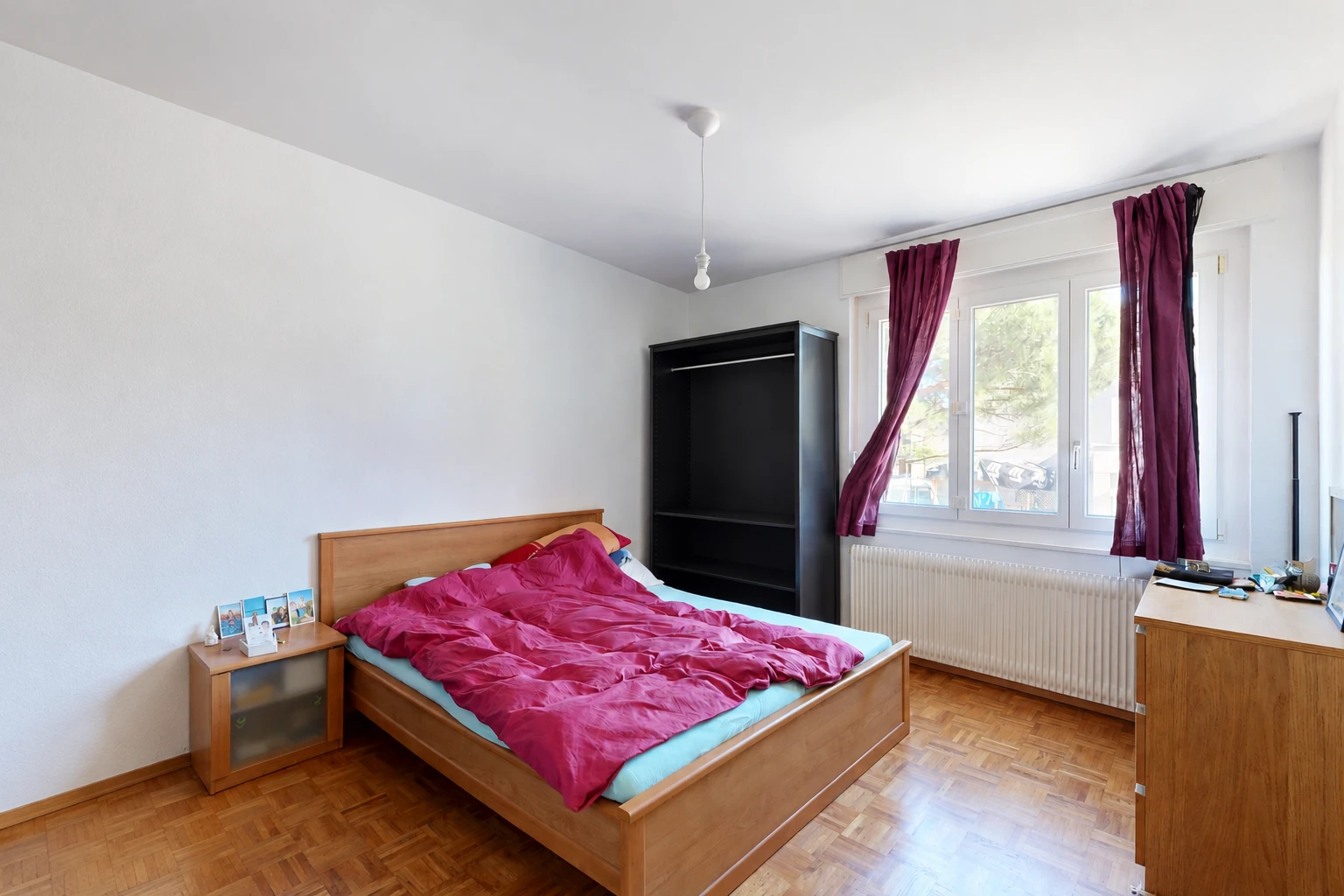 chambre avec radiateur, cloison sèche, drywall, sol en finition bois, et wood finish floor