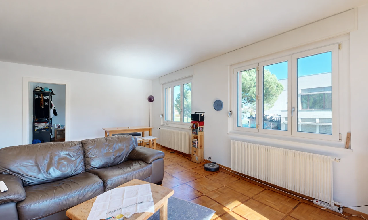 salon avec radiateur, cloison sèche, drywall, inside property, et lumière naturelle