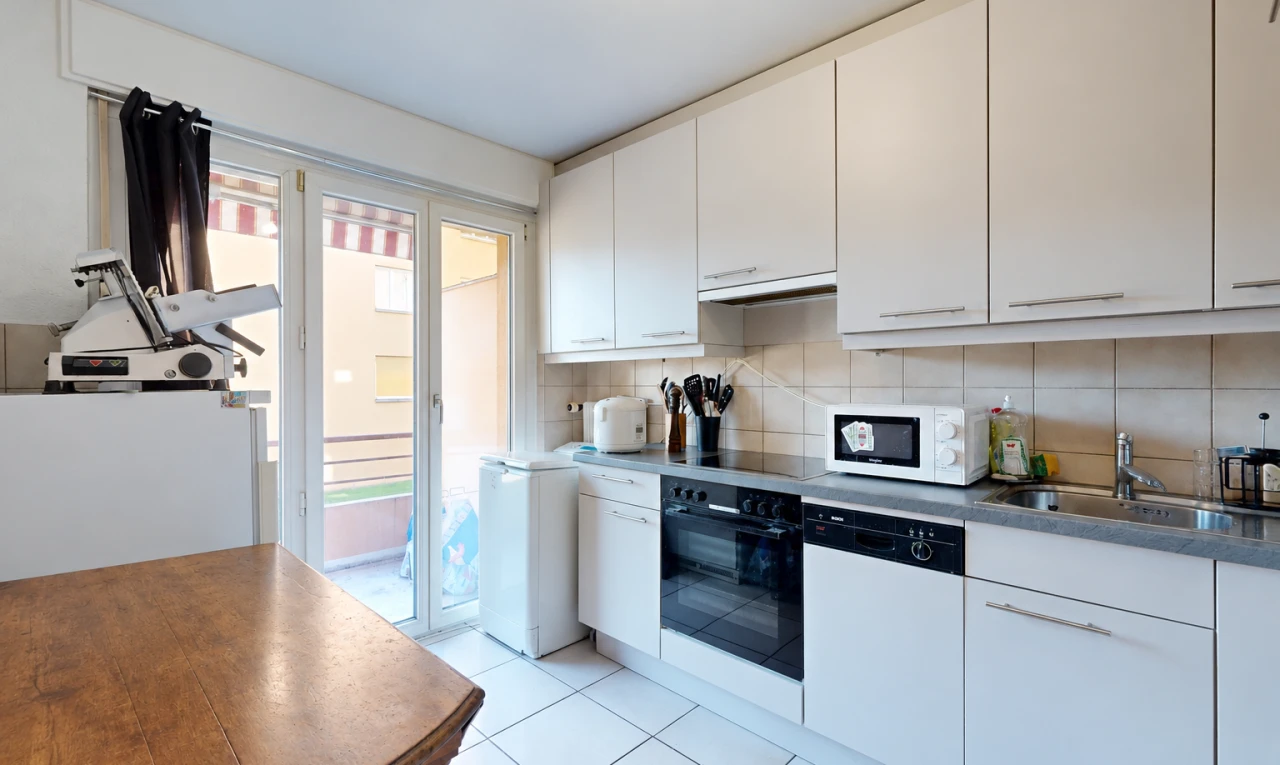 cuisine avec four, light floor, accès à l'extérieur, armoires blanches, et white cabinets