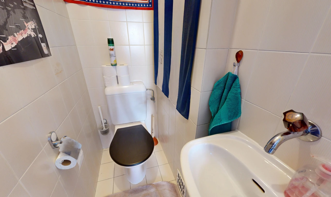 salle de bains avec toilette, mur en carrelage, tile wall, inside property, et sol en carrelage