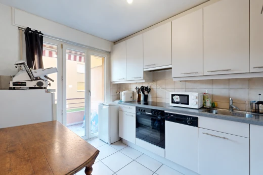 cuisine avec four, light floor, accès à l'extérieur, armoires blanches, et white cabinets