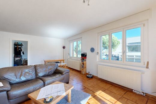 salon avec radiateur, cloison sèche, drywall, inside property, et lumière naturelle