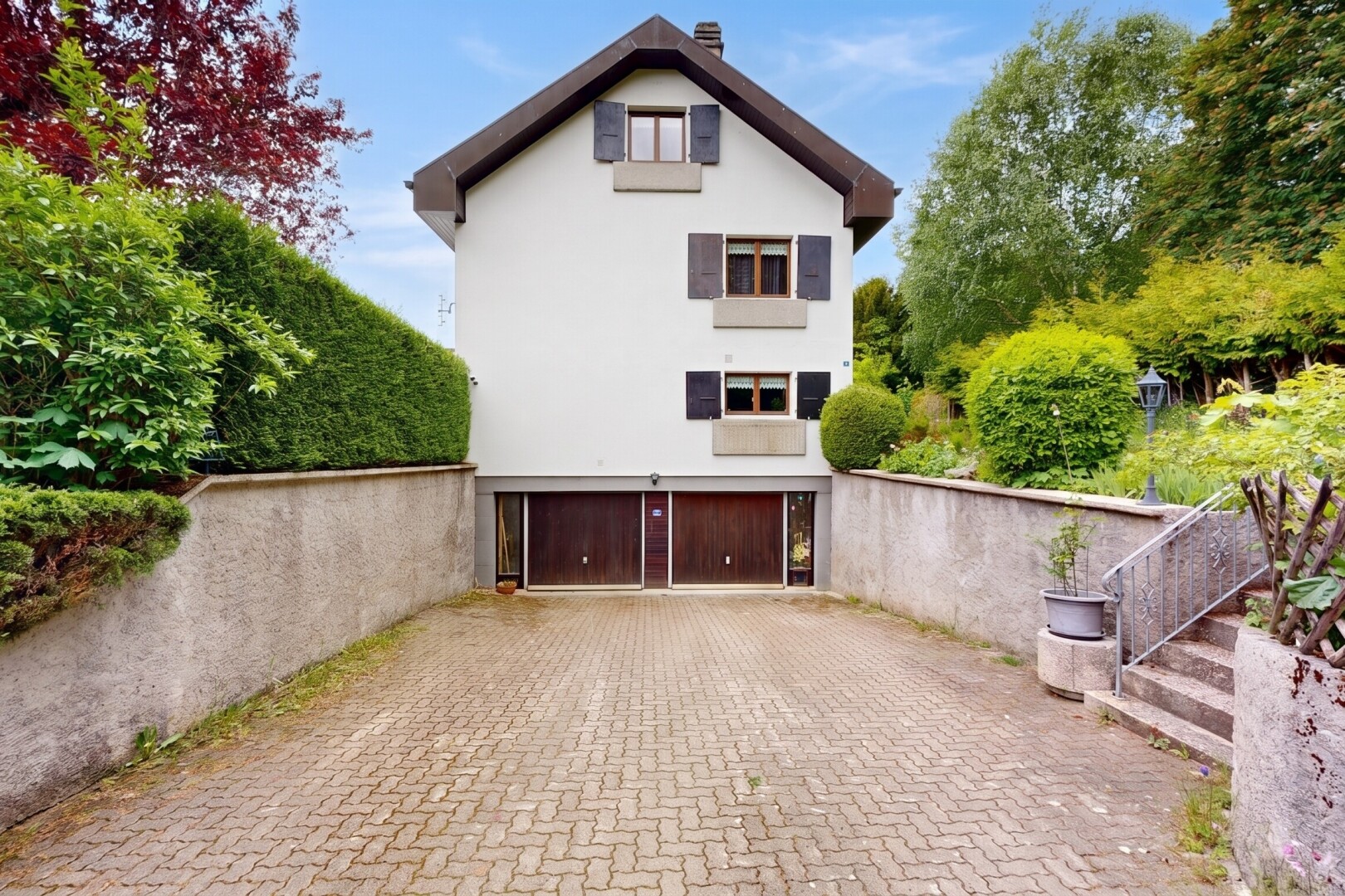 außenansicht mit stuckverkleidung, auffahrt, eingebaute garage, day time, und kellergarage