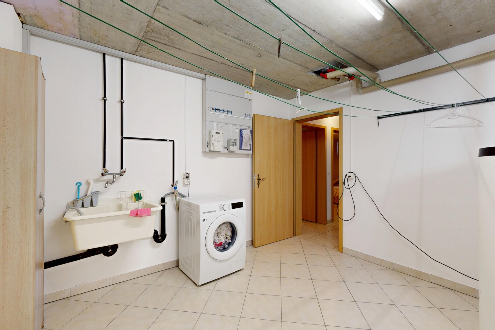 buanderie avec lave-linge et sèche-linge, évier, concrete ceiling, plafond en béton, et inside property