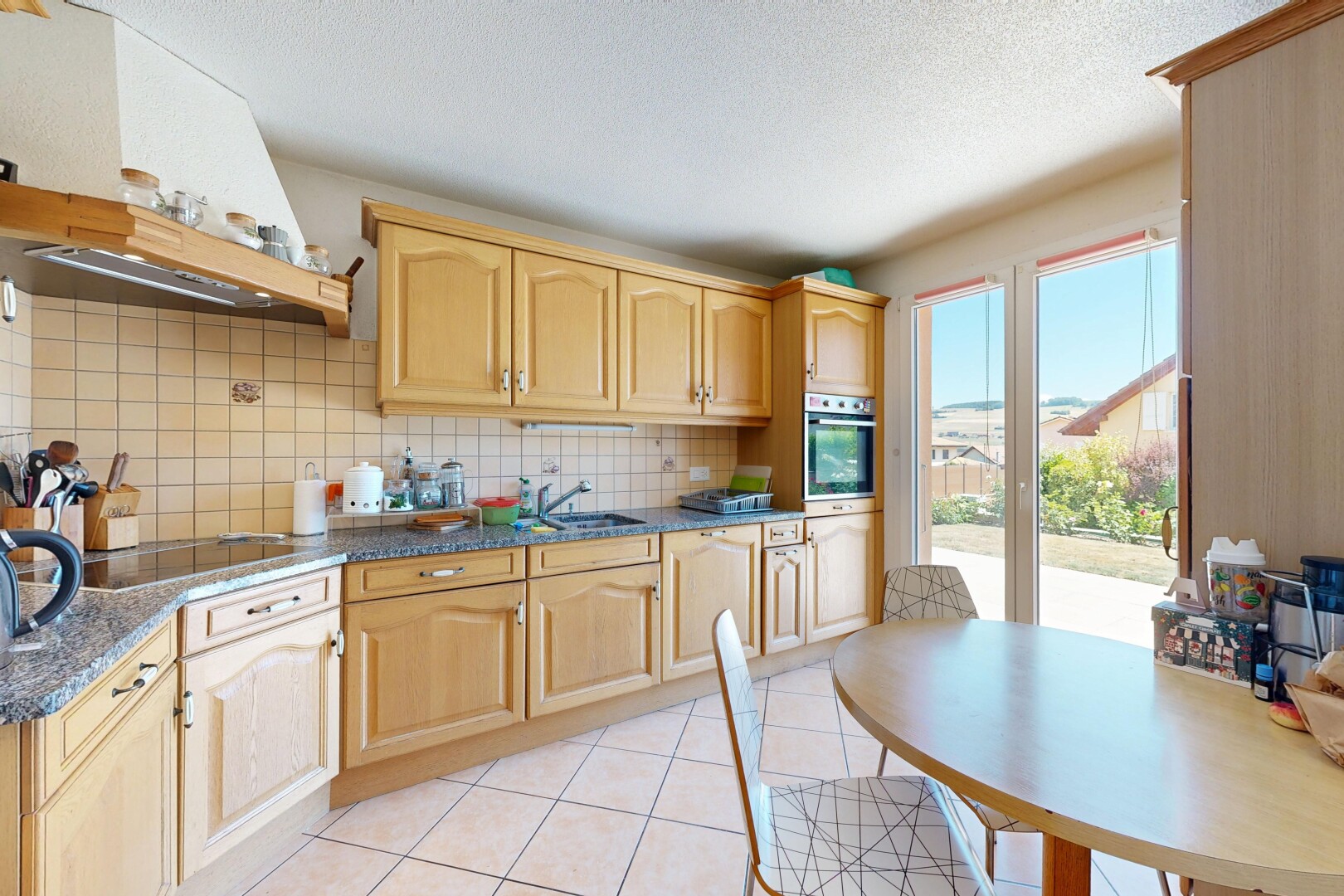 cuisine avec arched cabinets, armoires en arc, backsplash, dosseret, et light brown cabinets