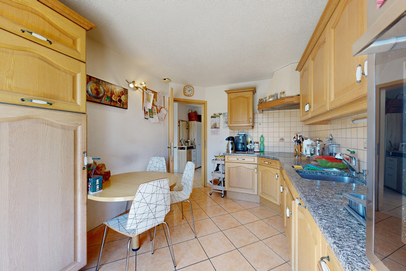 cuisine avec armoires en arc, arched cabinets, armoires marron clair, light brown cabinets, et backsplash