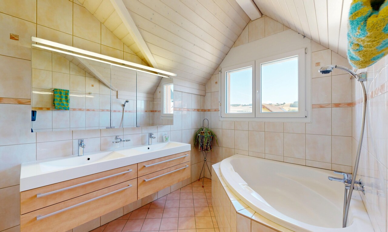 salle de bains avec salle de bain complète, tile wall, mur en carrelage, double vasque, et vaulted ceiling