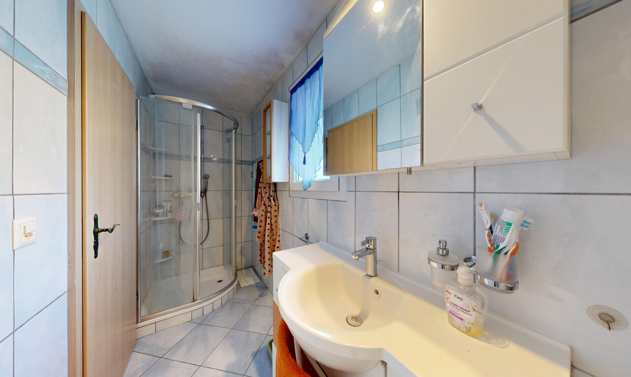 salle de bains avec douche, tile wall, miroir, mur en carrelage, et lavabo (ou coiffeuse selon le contexte)
