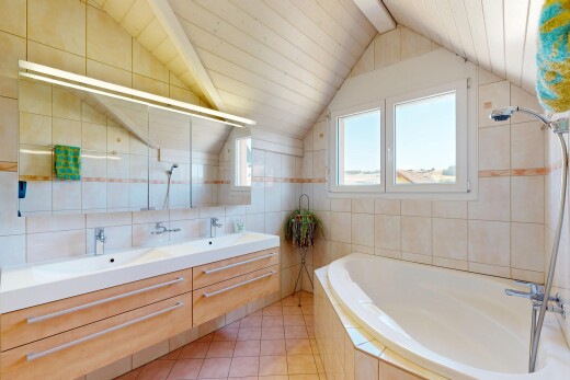 salle de bains avec salle de bain complète, tile wall, mur en carrelage, double vasque, et vaulted ceiling